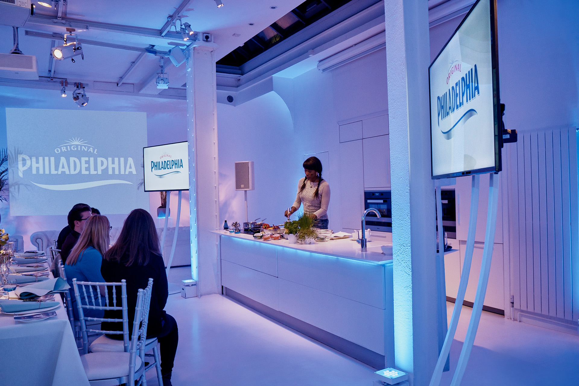 Private dining event in modern Icetank space with culinary demonstration setup.
