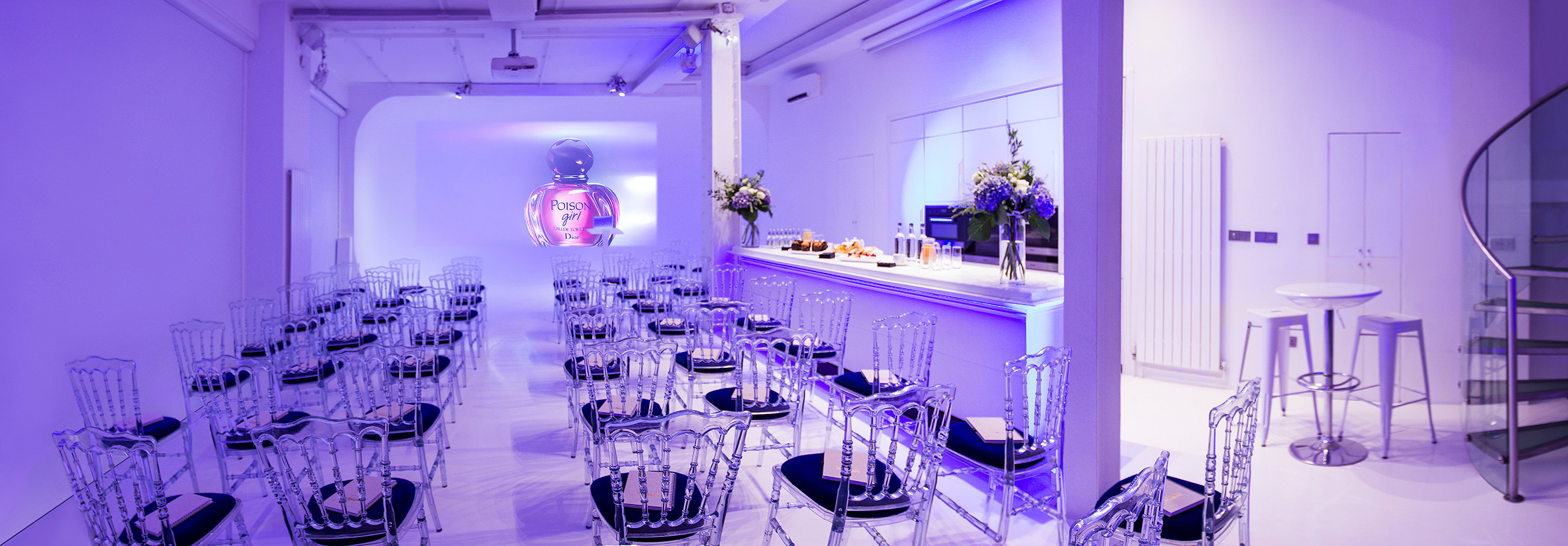 Modern corporate event space with acrylic chairs and elegant blue lighting.