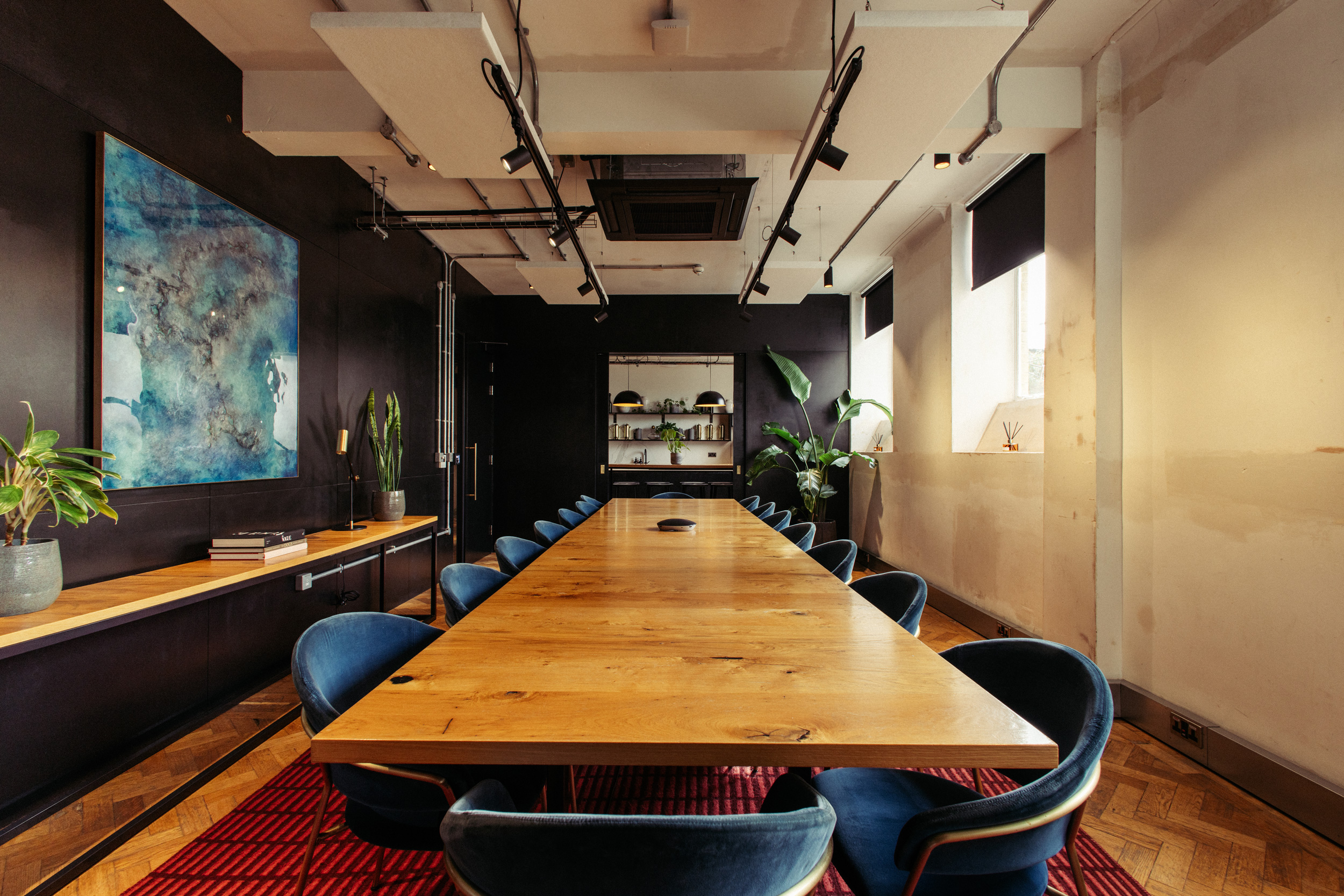 Modern meeting room with wooden table, blue chairs for collaboration and brainstorming.