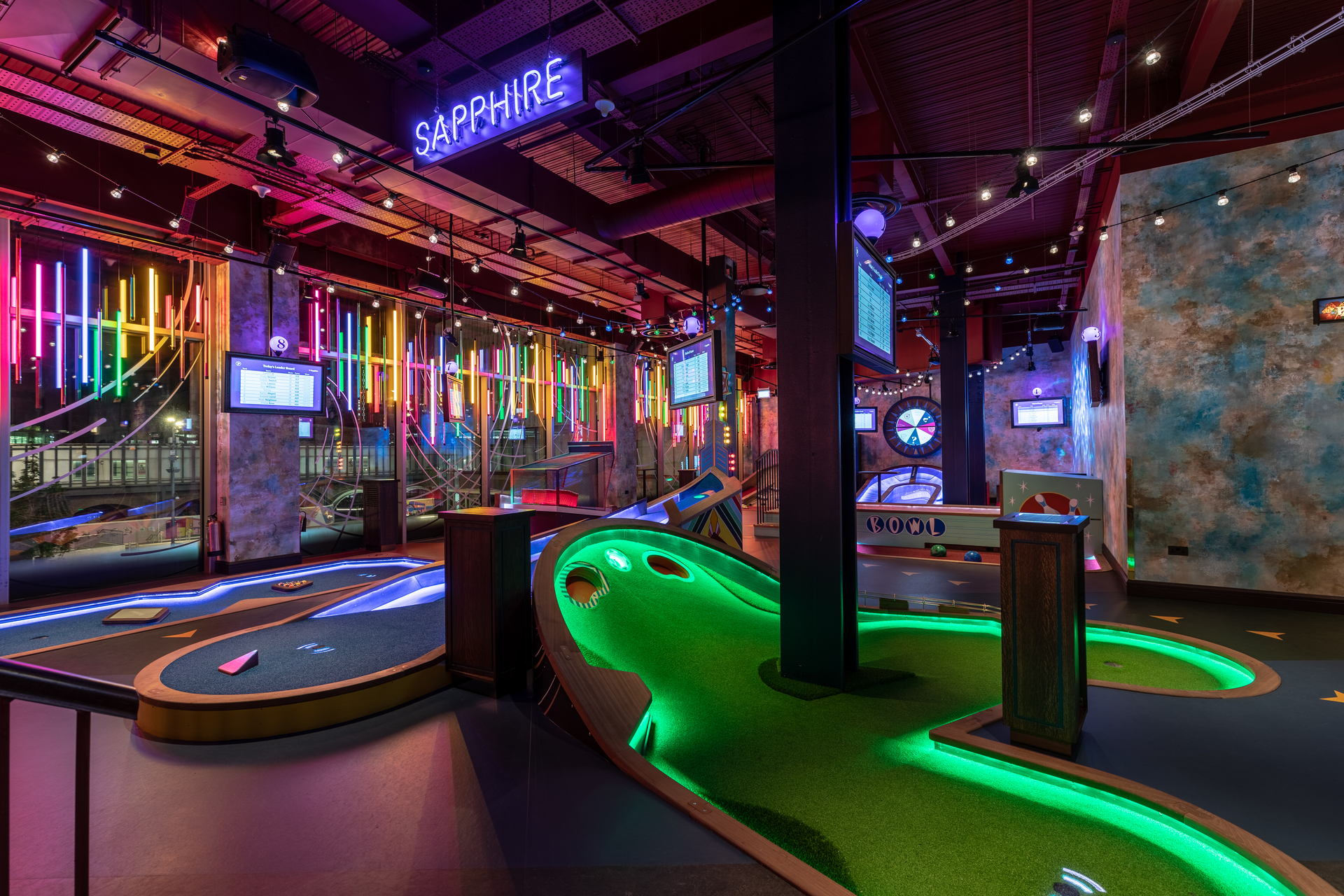 "Vibrant mini-golf venue for Christmas corporate events with colorful neon lights."
