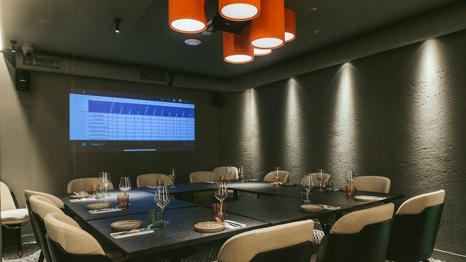 Private meeting room with projector at Bennie Restaurant & Bar for professional events.