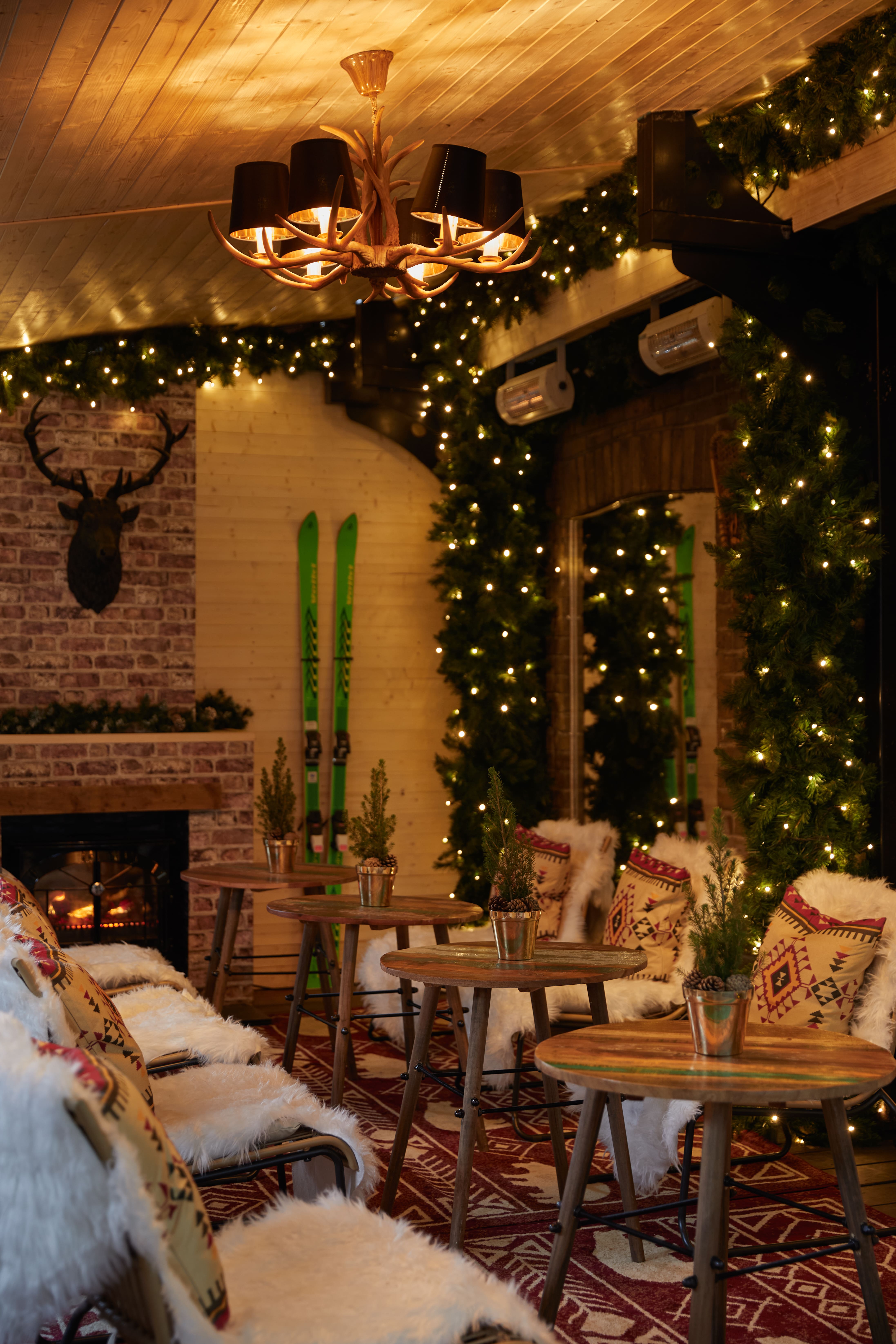 Cozy winter lodge event space with fireplace, perfect for holiday gatherings.