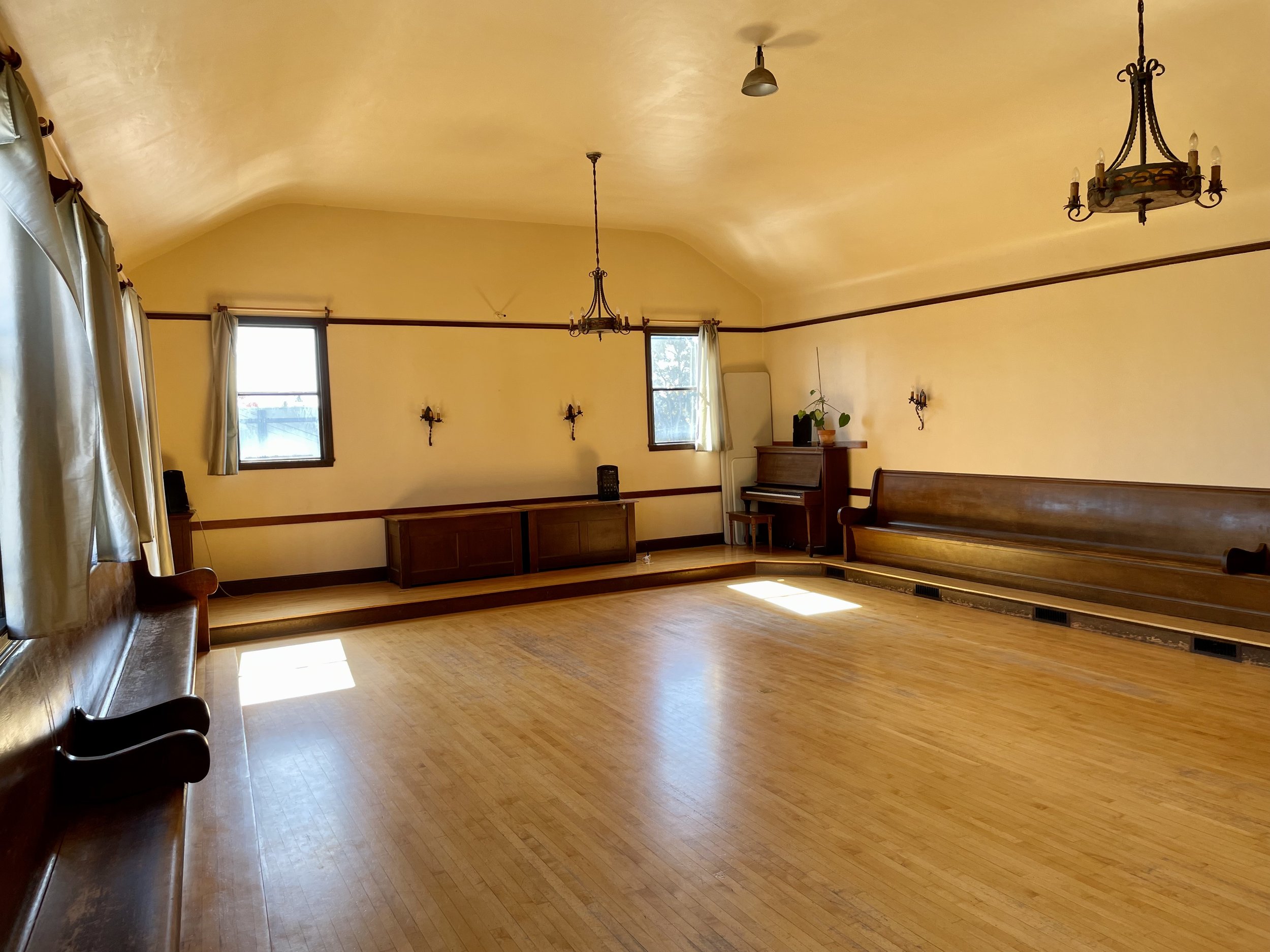 Spacious meeting room with wooden flooring for workshops and gatherings at Finnish Hall.