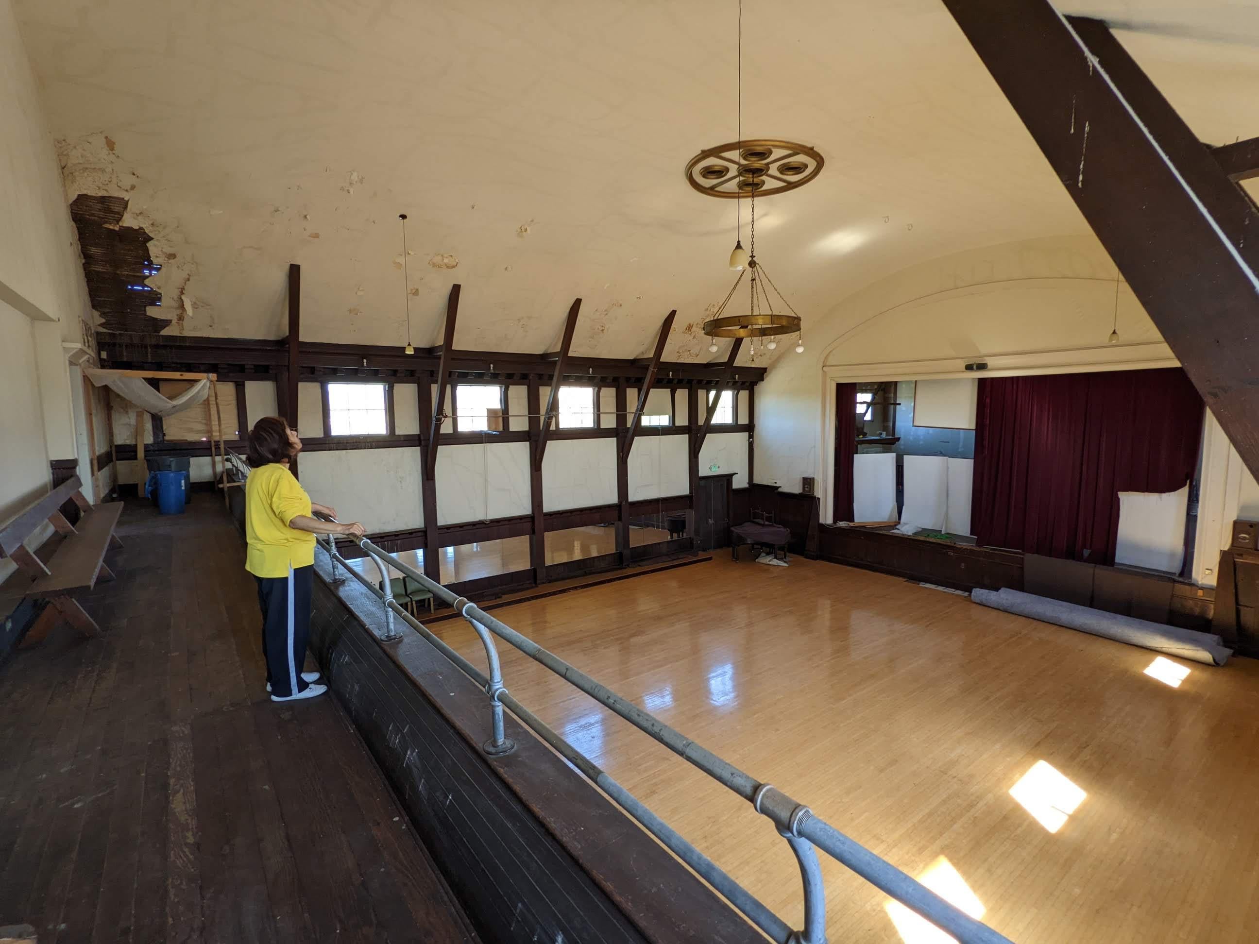 Spacious vintage auditorium with wooden floors, ideal for workshops and gatherings.