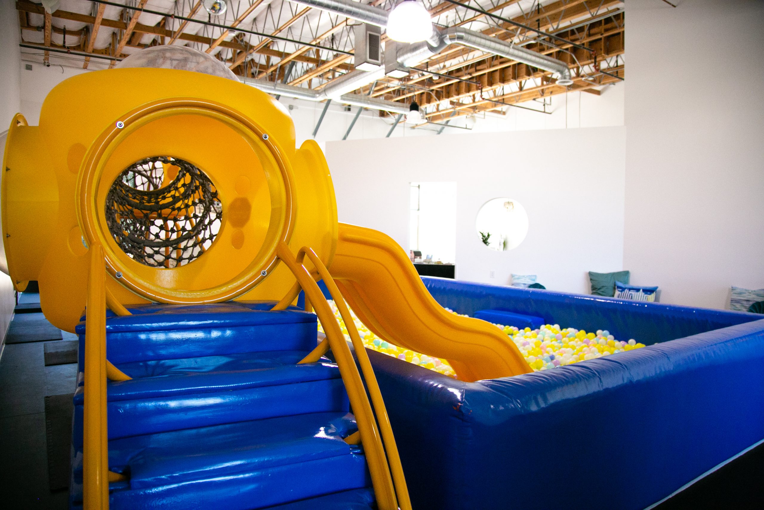 Vibrant play area with yellow slide and ball pit for family-friendly events.