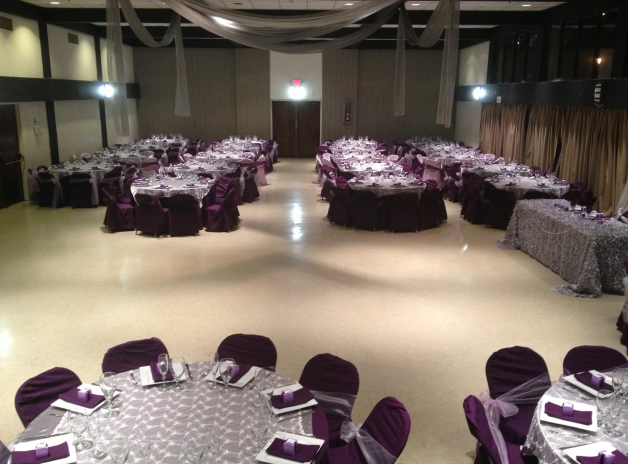 Elegant auditorium setup with purple linens for weddings and corporate events.