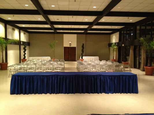 Auditorium at Ashkenaz Center set for a meeting with elegant blue table and clear chairs.
