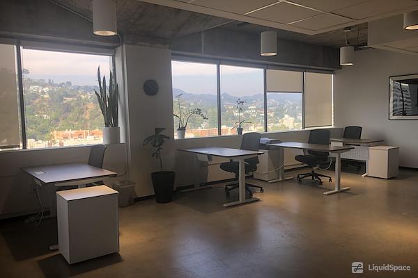 Modern minimalist workspace with large windows, ideal for team meetings and creativity.