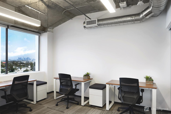 Modern minimalist office space with natural light, ideal for meetings and collaboration.