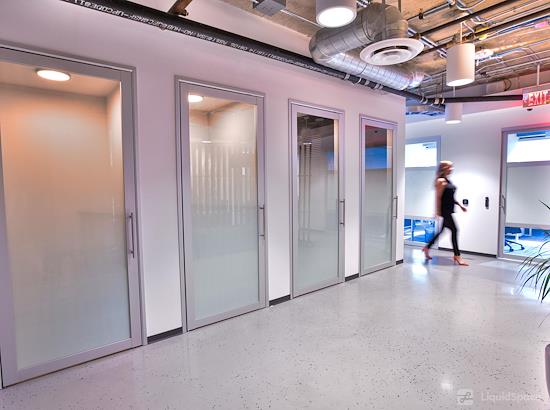 Modern office space with glass-walled meeting rooms for collaborative meetings.