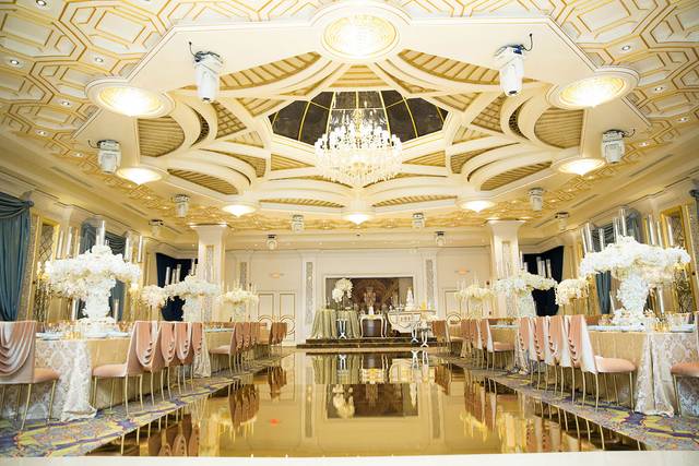 Elegant banquet hall with chandelier, perfect for weddings and corporate events.