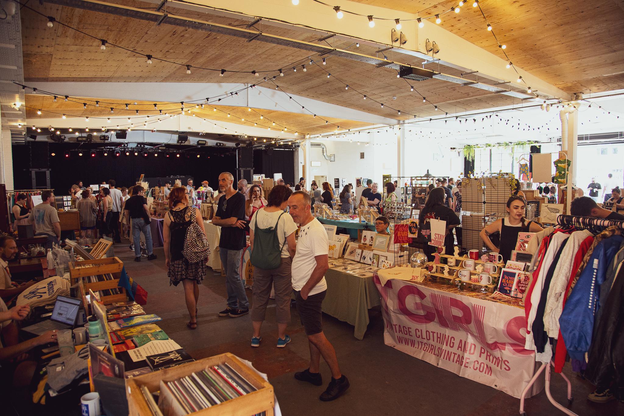 Vibrant event space with vendor booths for networking and shopping in Project House.