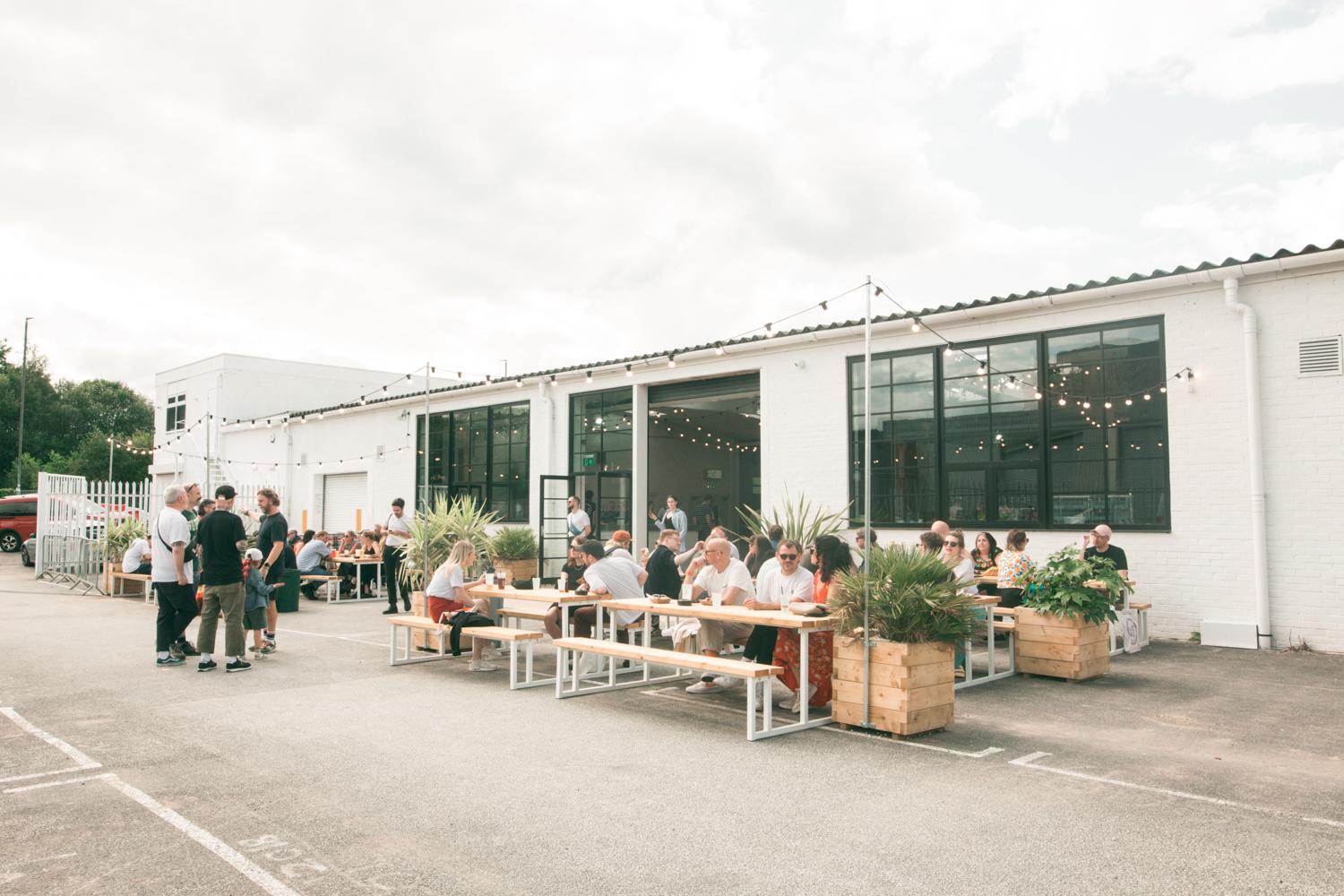 Vibrant outdoor event space with communal tables, ideal for gatherings and networking.