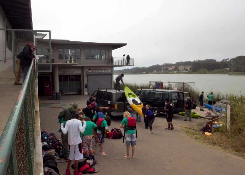 Outdoor team-building event at Lake Merced Boathouse with kayaking setup.