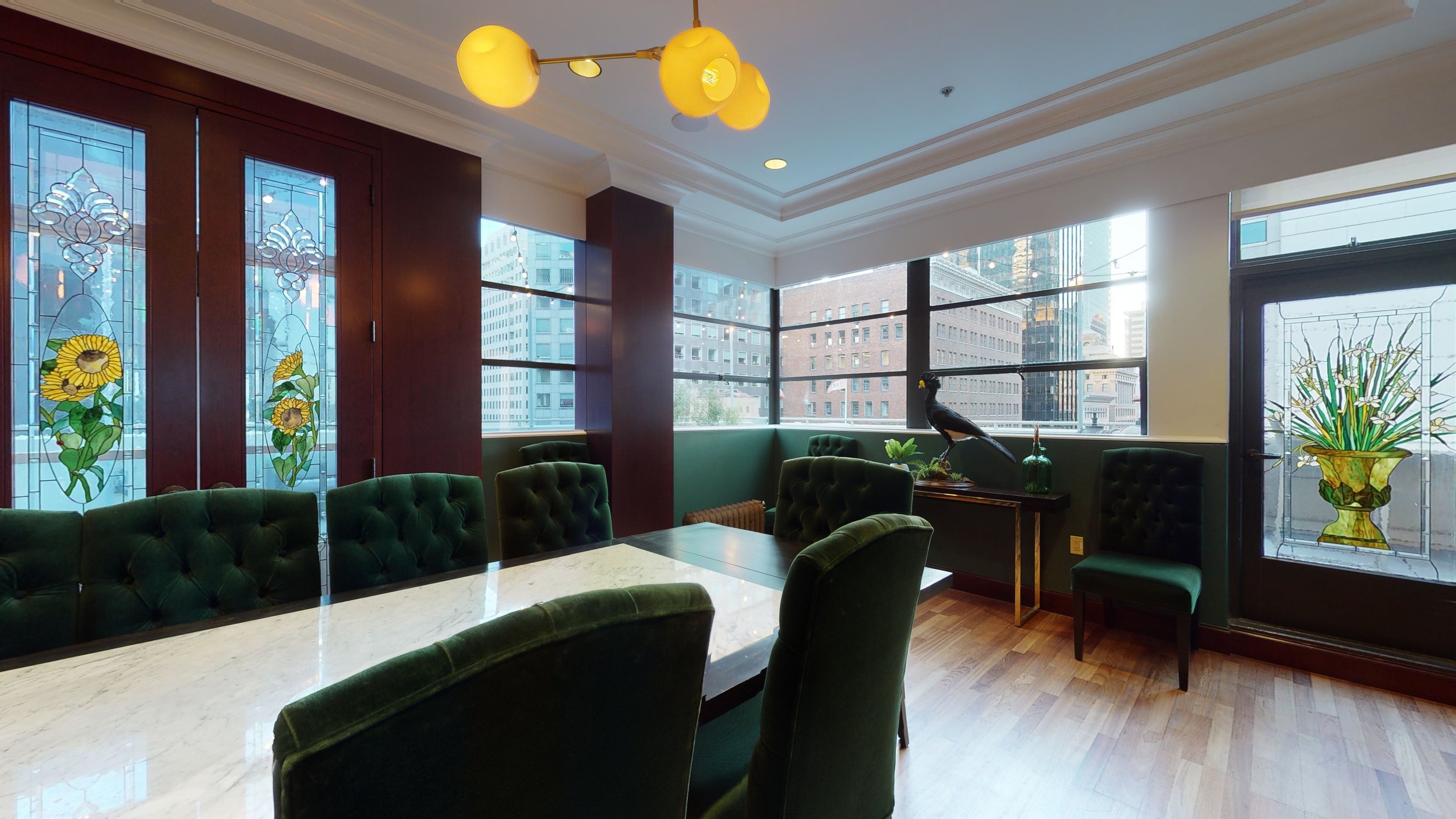 Sophisticated conference room with marble table and plush green chairs for meetings.