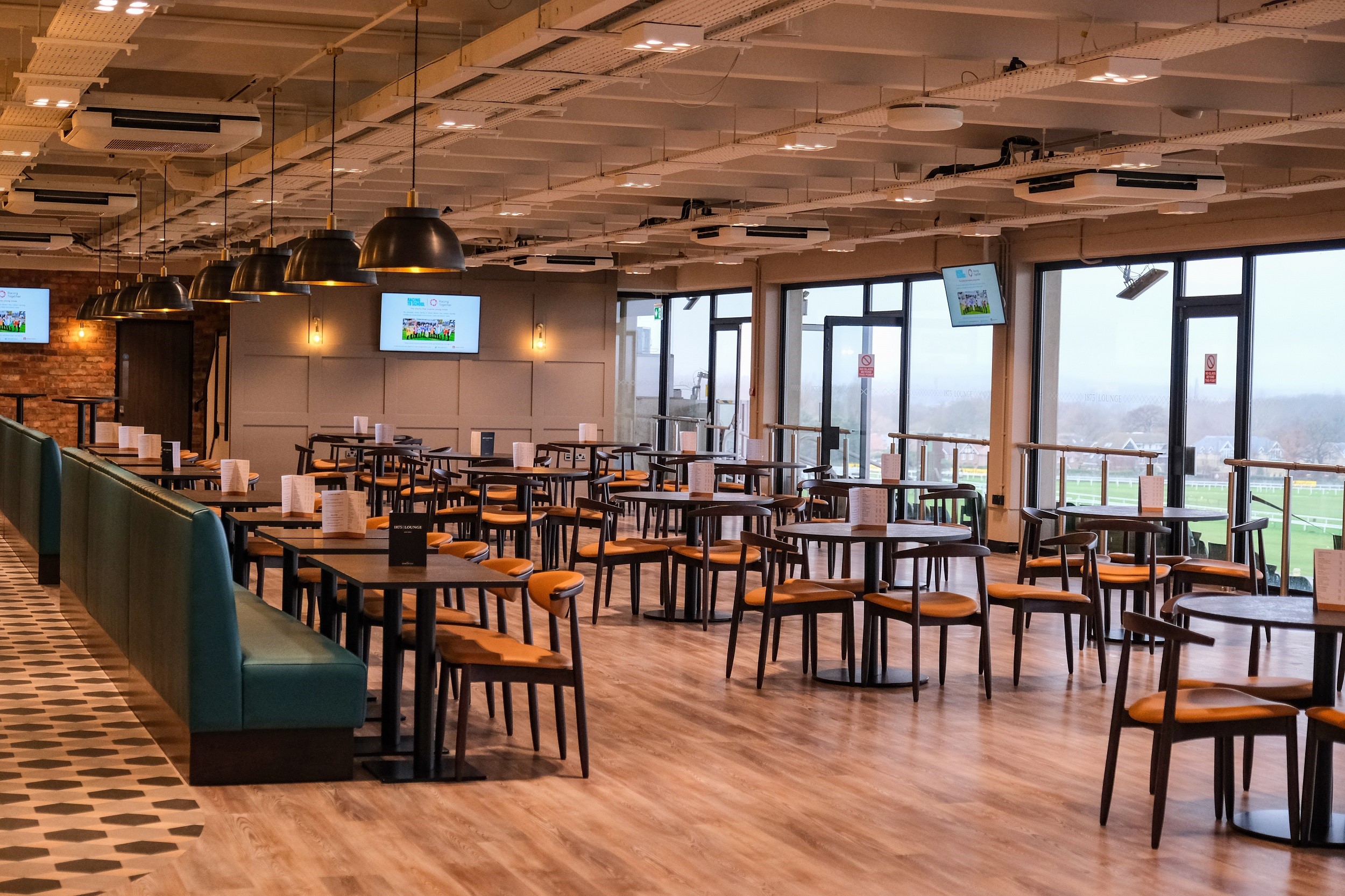 Spacious 1875 Lounge at Sandown Park for corporate events with modern design and natural light.