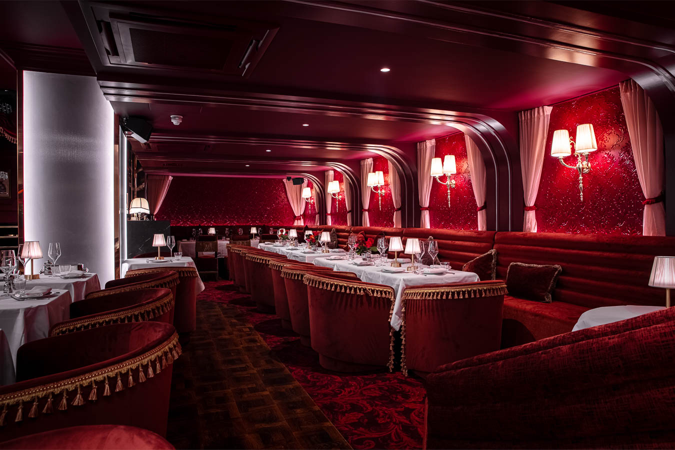Elegant semi-private dining area with rich red decor, ideal for upscale events and gatherings.