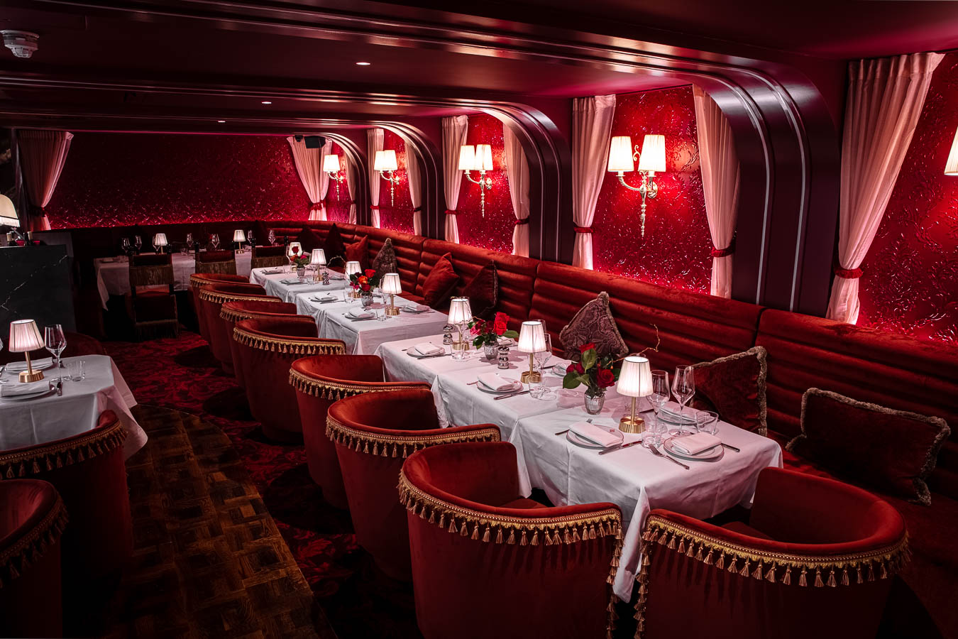 Elegant semi-private dining area with rich red decor for upscale events and intimate gatherings.