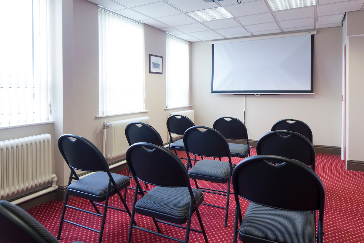 Mather Avenue Army Reserve Centre meeting room with black chairs, ideal for workshops and conferences.