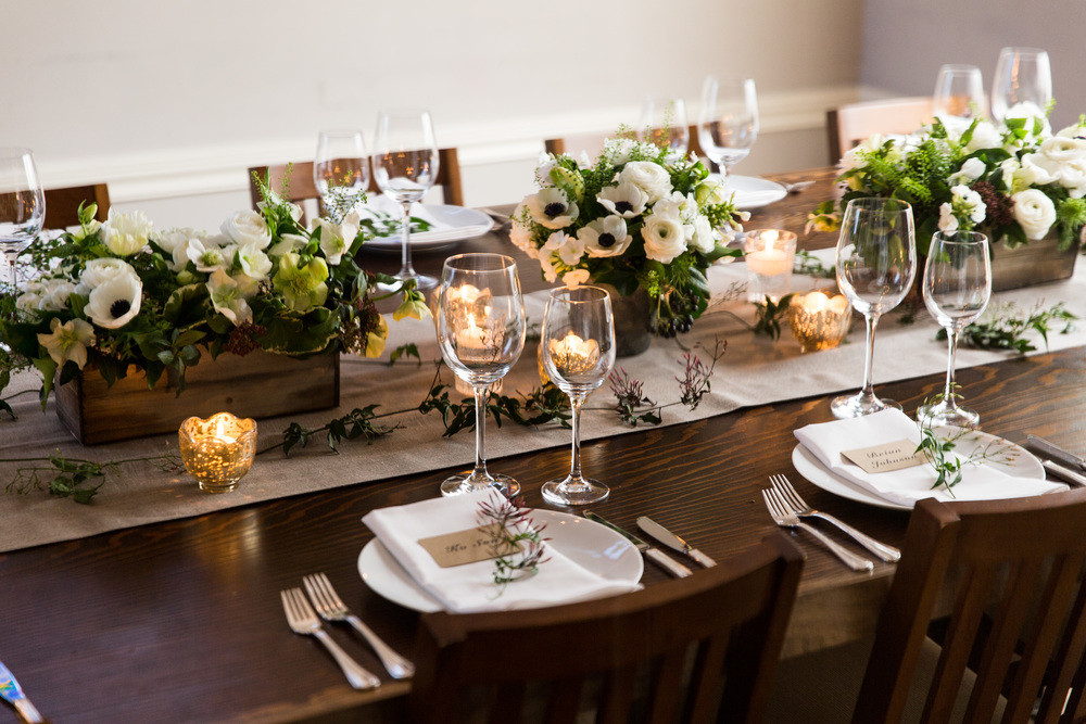 Elegant outdoor dining table with floral centerpieces for upscale events.