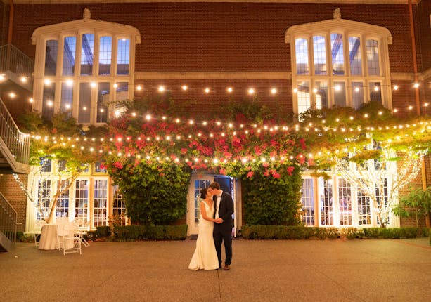 "Elegant outdoor wedding venue at Kohl Mansion with string lights and lush greenery."