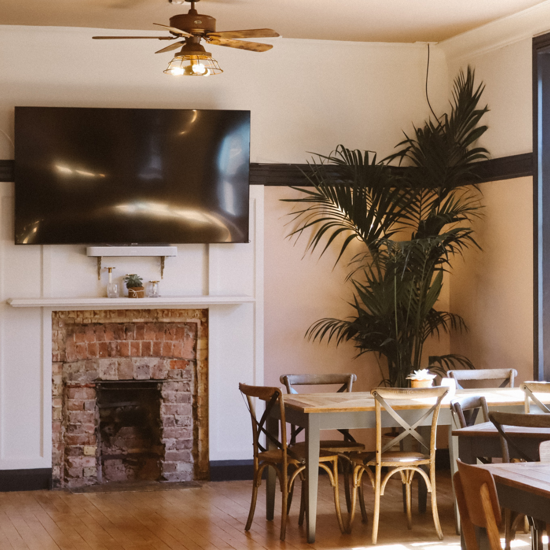 Versatile meeting space with wall-mounted screen, ideal for workshops and presentations.