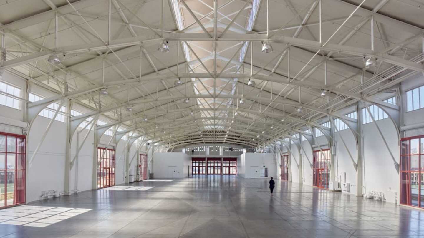 Spacious Fort Mason Auditorium with high ceilings, ideal for conferences and exhibitions.