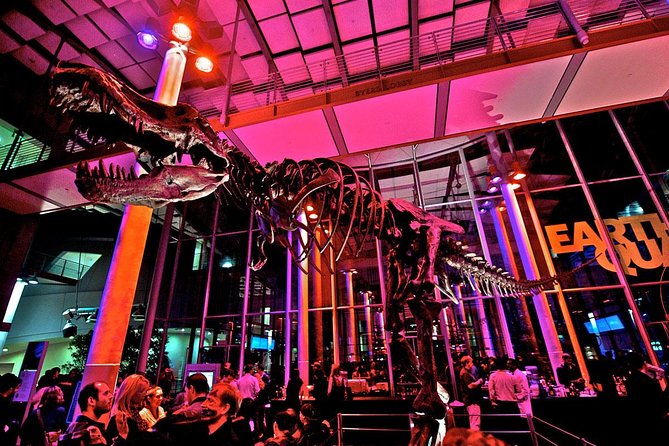 Dinosaur skeleton centerpiece in vibrant Academy SF event space for networking and galas.
