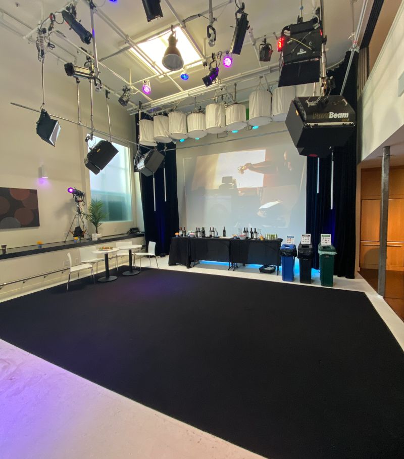 Black Limbo event space with projection screen, ideal for meetings and gatherings.