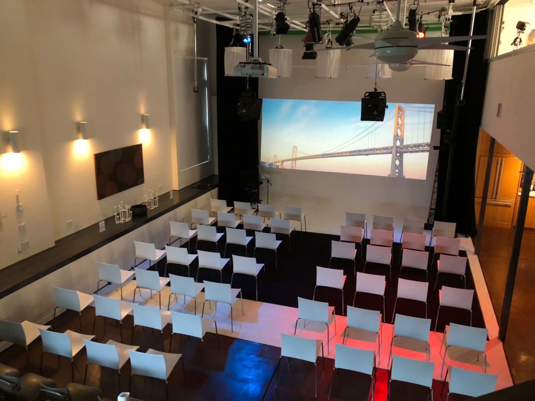 Event space with theater seating and large screen for presentations and meetings.