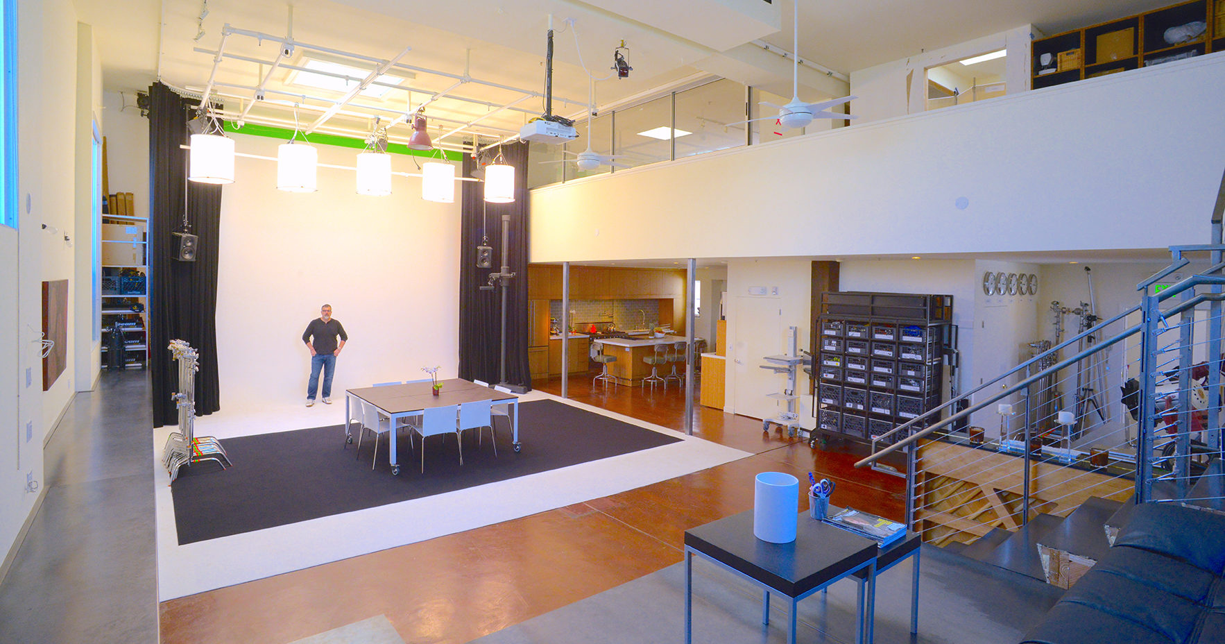 Versatile event space with large white backdrop for meetings and productions.