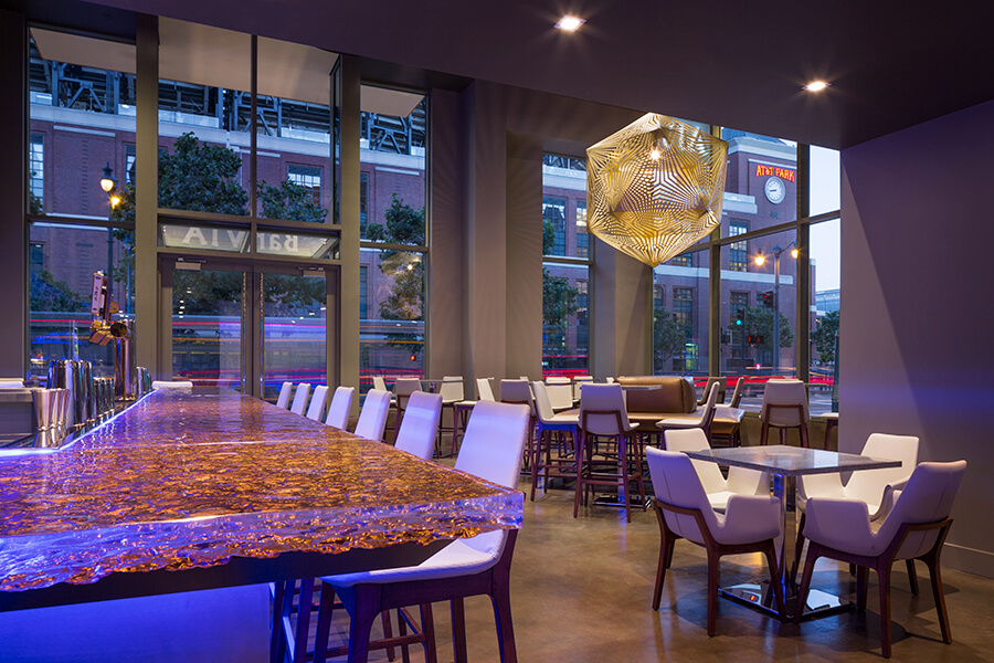 Modern event space at Hotel VIA with illuminated bar, ideal for networking and receptions.