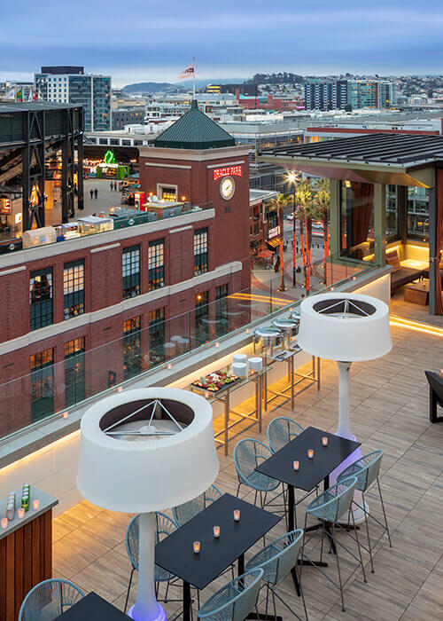 Stylish outdoor reception space at Hotel VIA with modern furnishings and urban backdrop.
