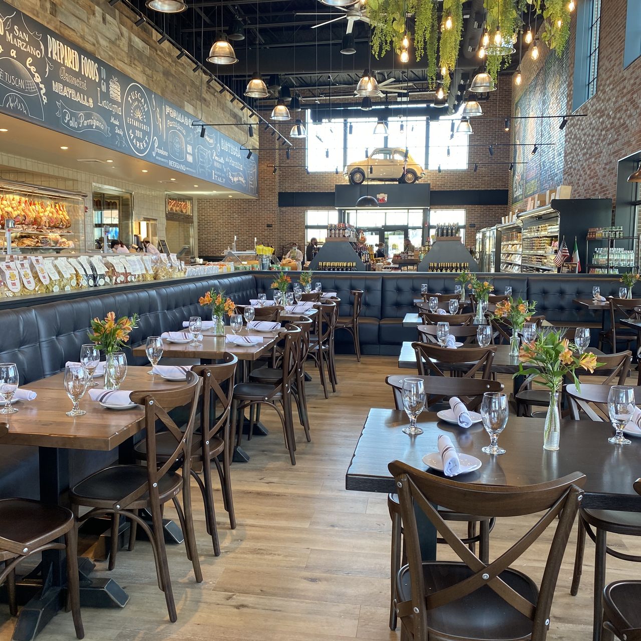 Elegant event space in Marzano Restaurant with wooden tables and floral decor.
