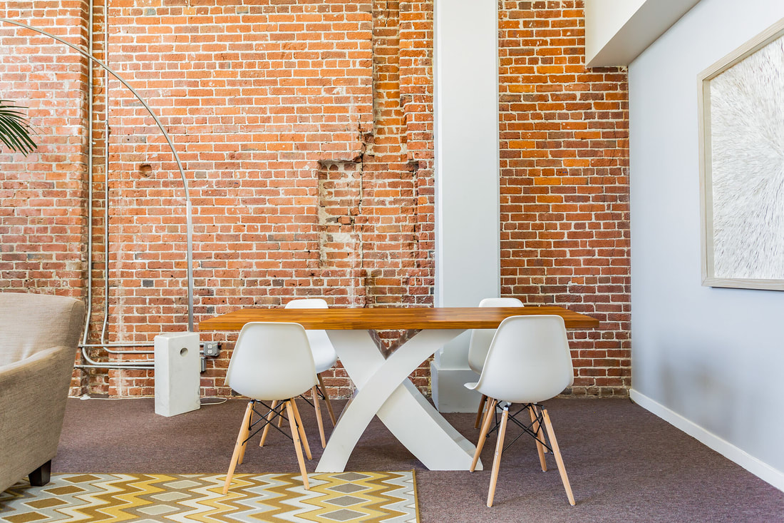 Modern meeting space with wooden table and white chairs, perfect for workshops and discussions.