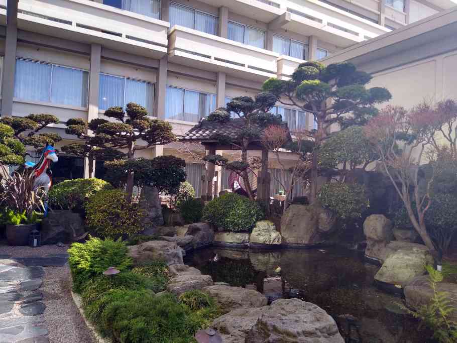 Serene Hotel Kabuki courtyard with bonsai trees, perfect for outdoor receptions and events.