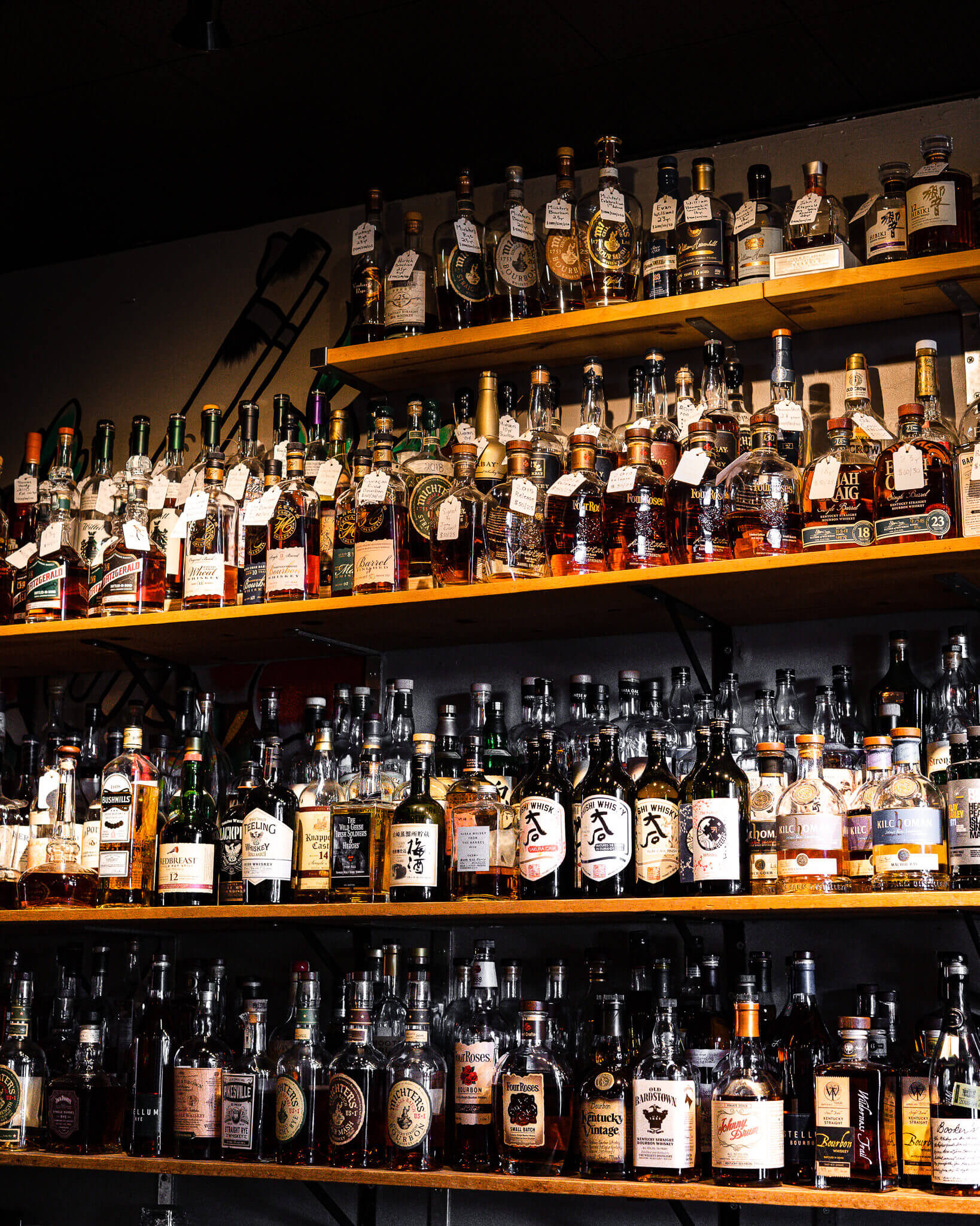 Private room bar at Acme Bar & Company with diverse spirits for events and tastings.