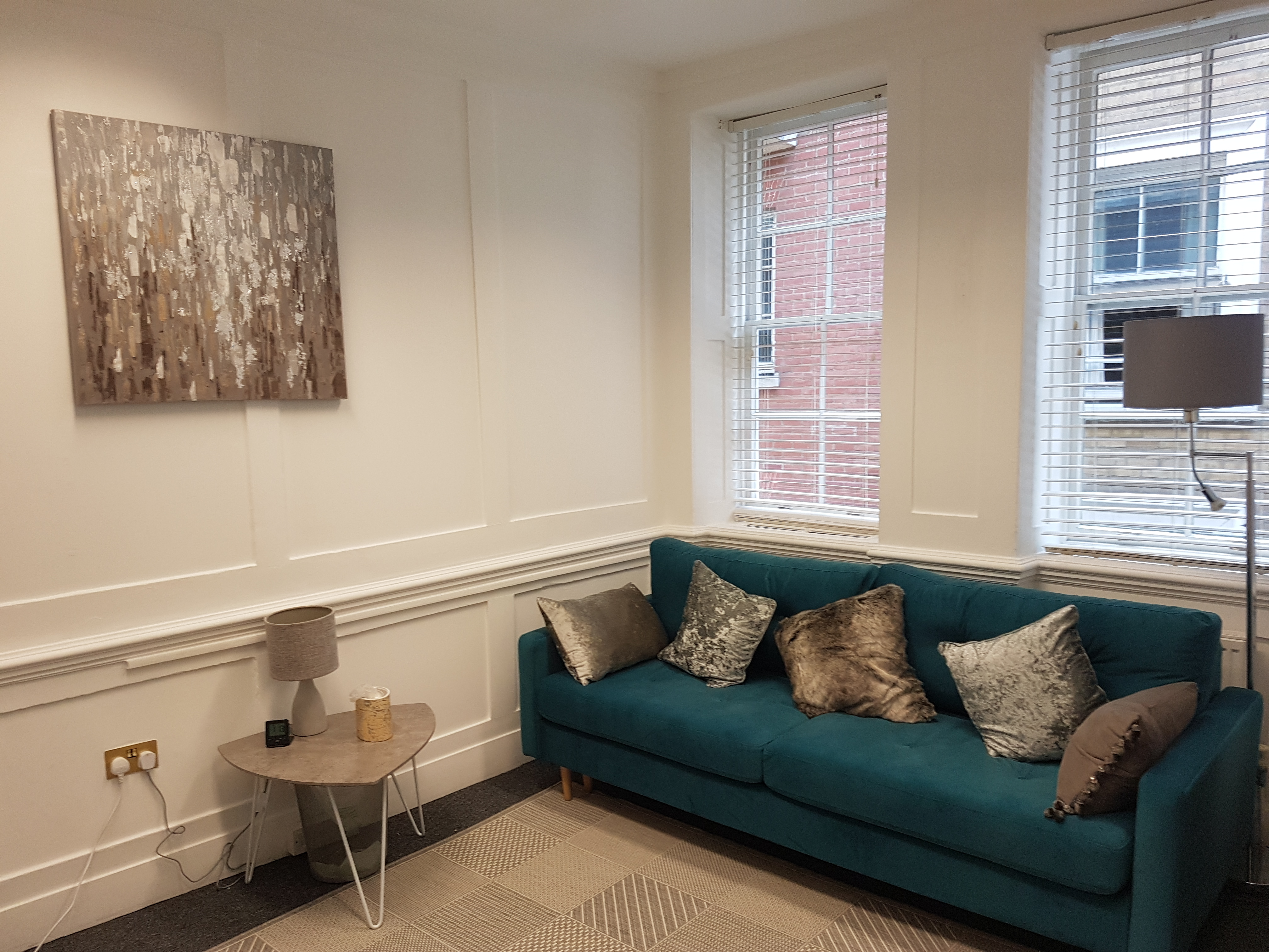 Cozy meeting space with teal sofa, ideal for informal gatherings and brainstorming sessions.