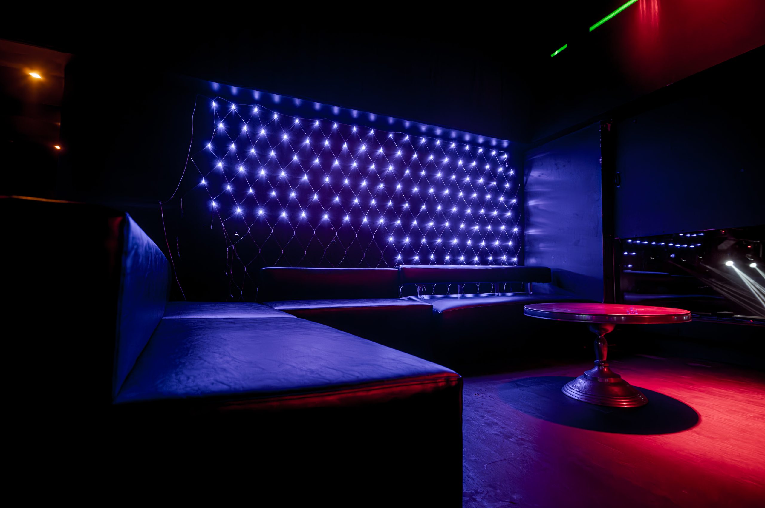VIP seating area with plush lounge and illuminated backdrop for stylish events.