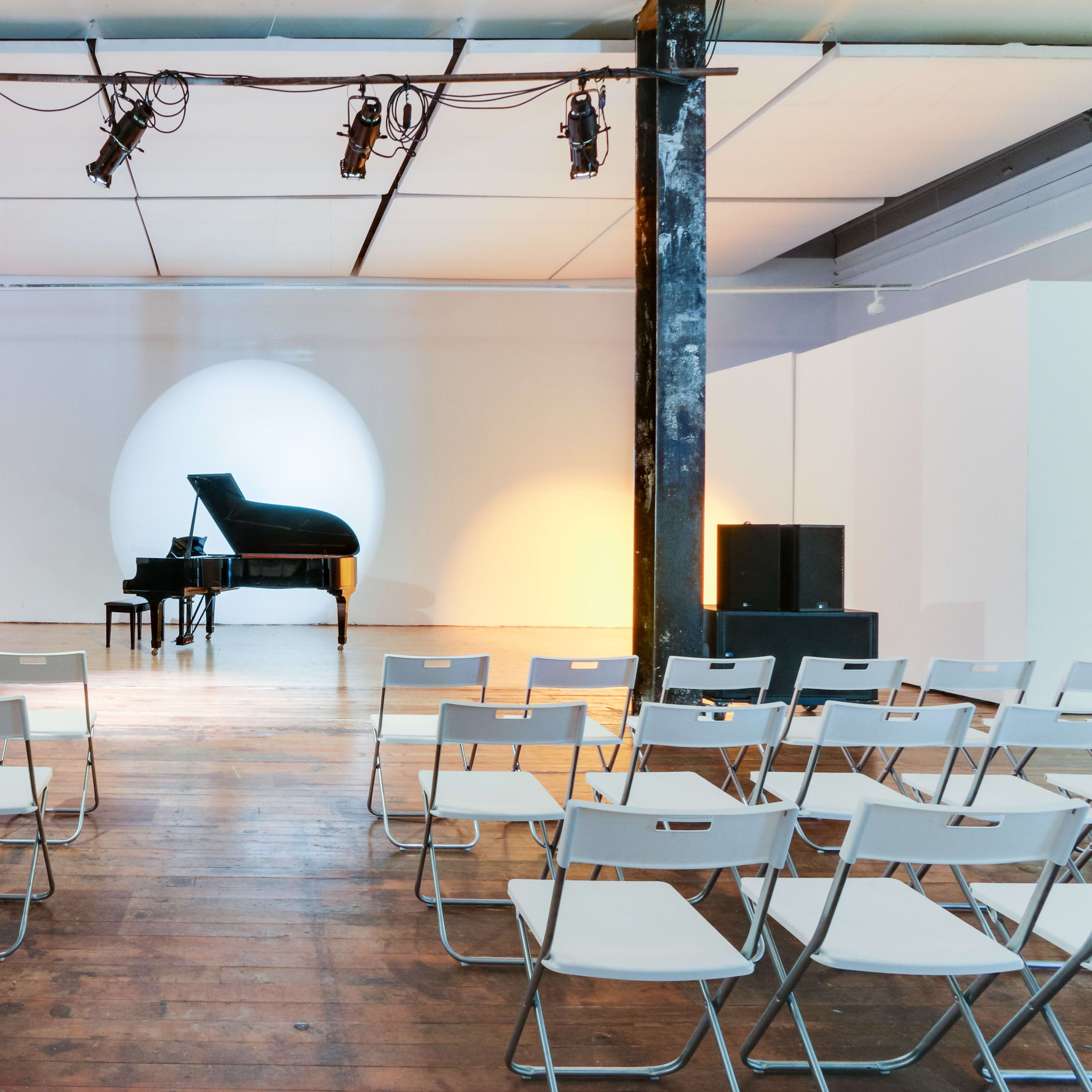 Minimalist event space with sleek piano for intimate musical performances in Mission Loft.