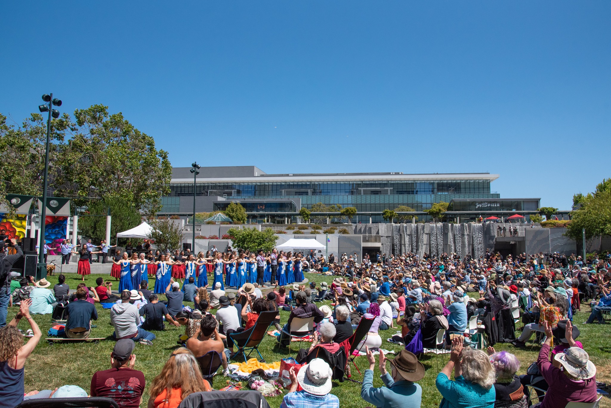 Jessie Square outdoor festival with vibrant performers and large audience enjoying cultural celebration.
