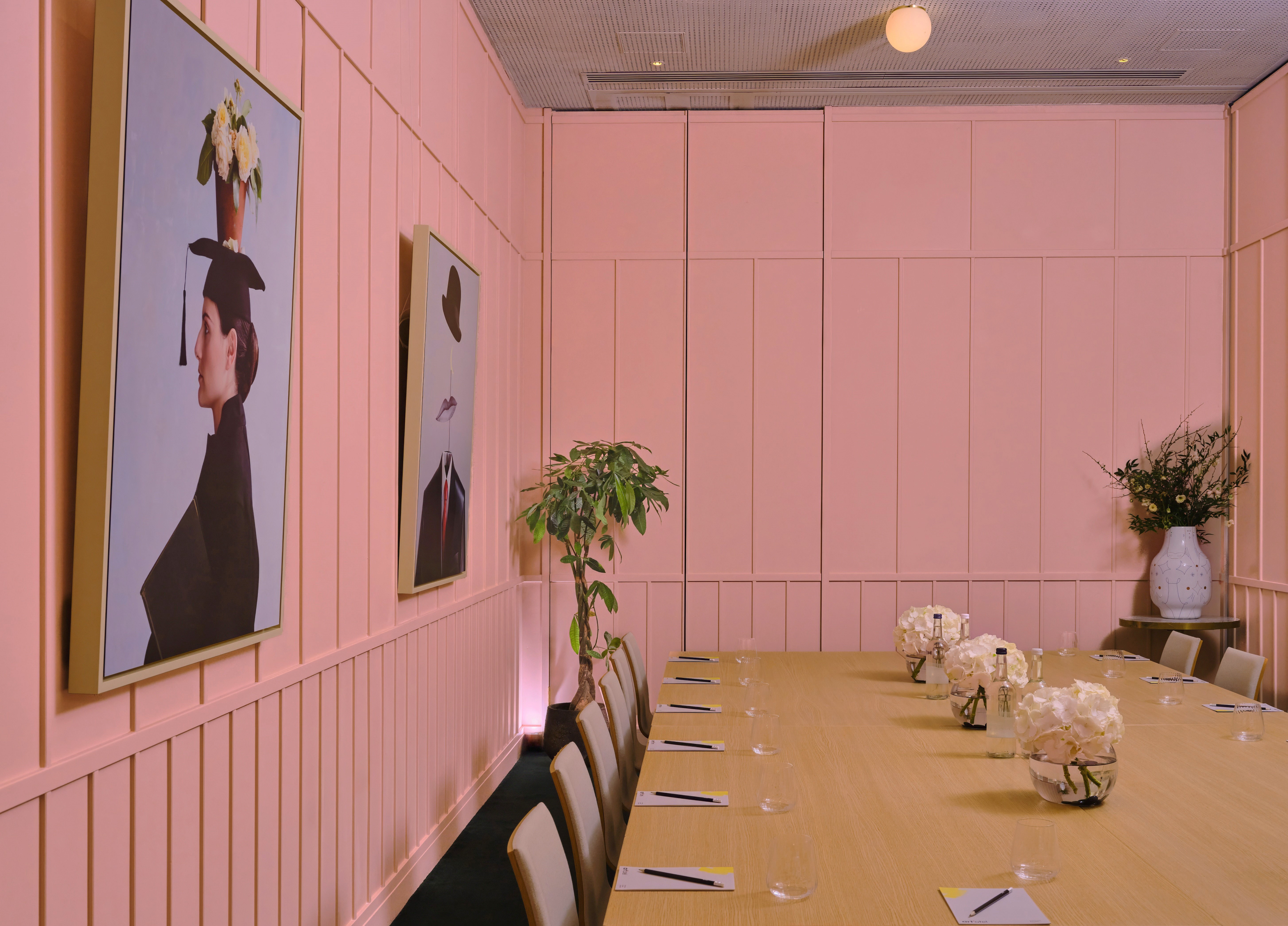 Stylish meeting room with wooden table and floral decor at art'otel London Battersea.