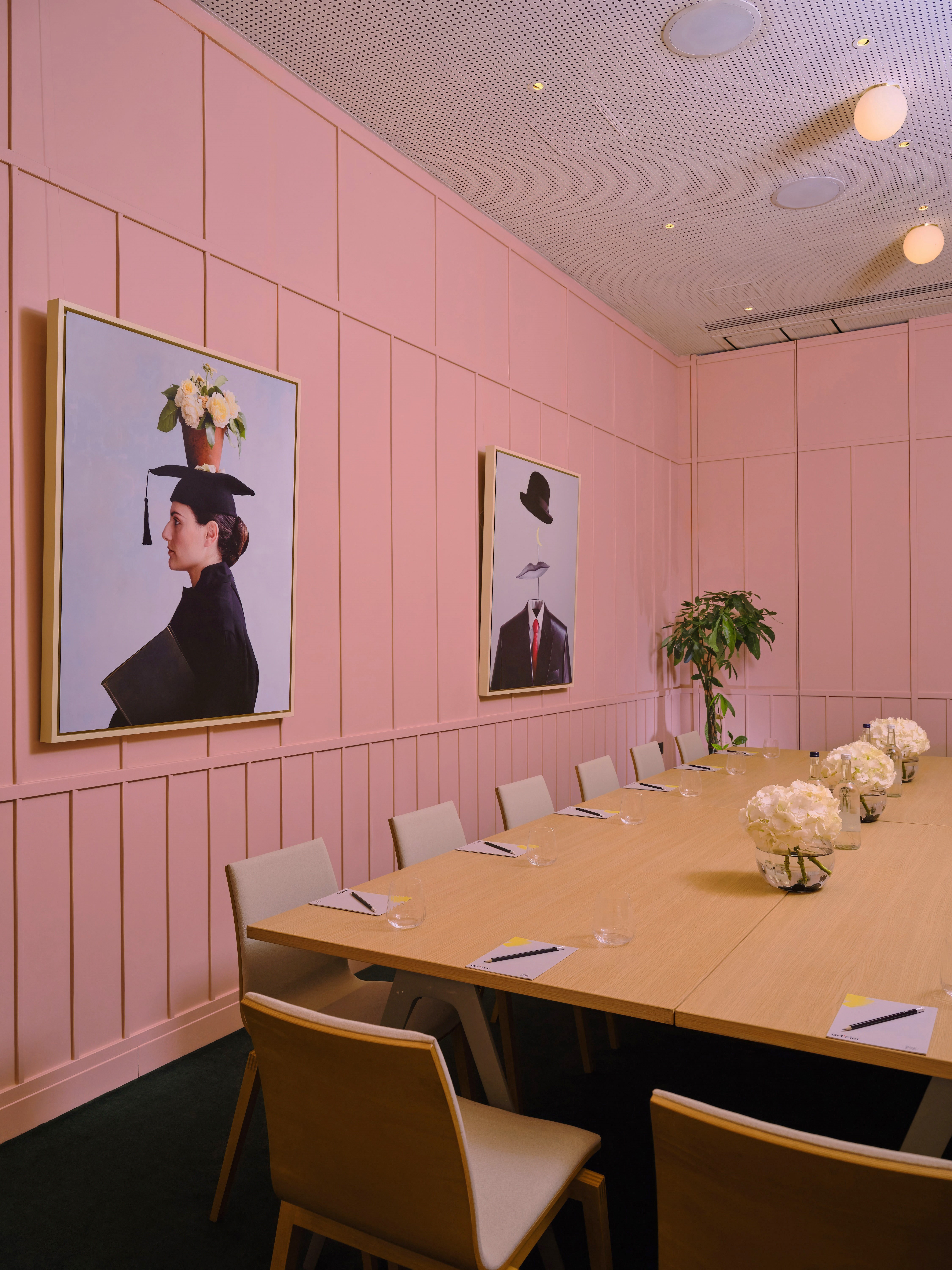 Stylish meeting room with wooden table and pink walls at art'otel London Battersea.
