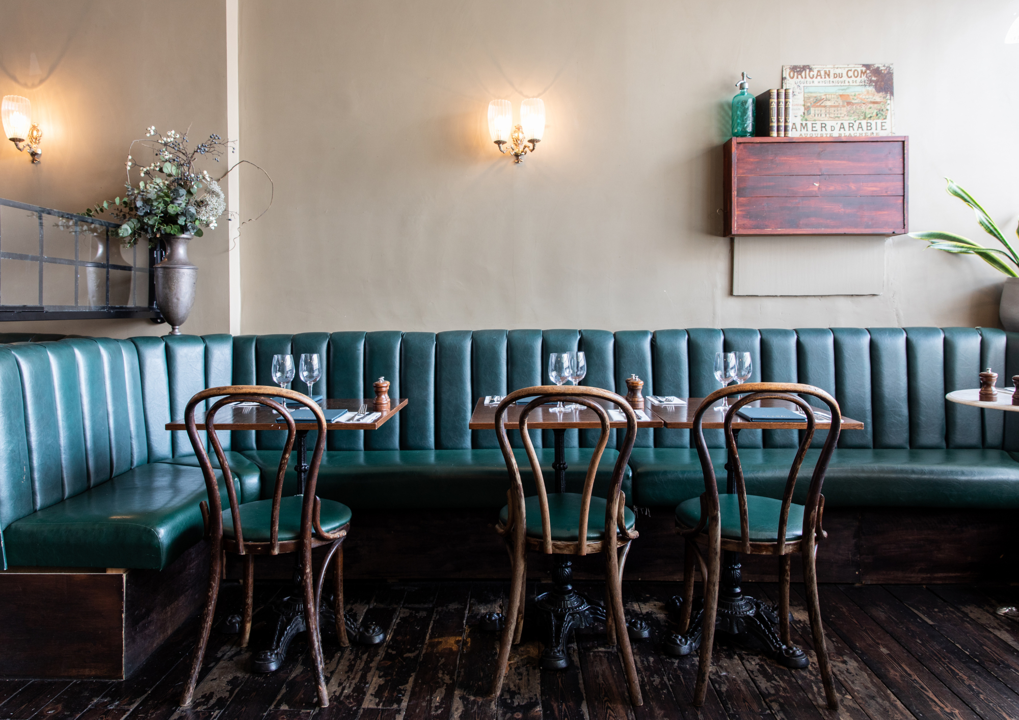 Stylish Bar & Bistro with green leather banquettes, perfect for intimate gatherings.