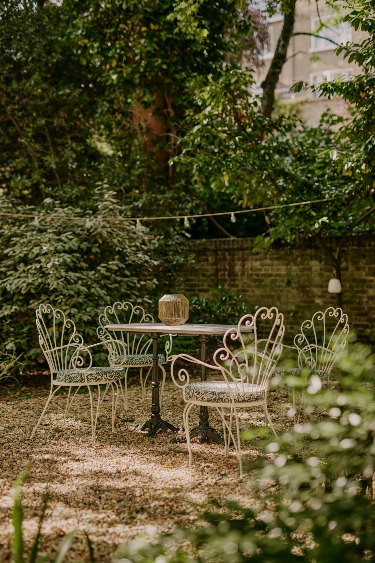 Charming EVE Kensington garden with wrought-iron furniture for events and gatherings.