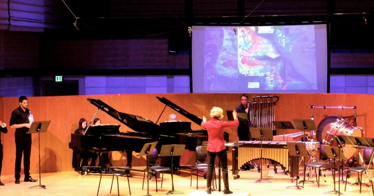 Ensemble-in-Residence rehearsal with conductor, pianos, and percussion for live performance.