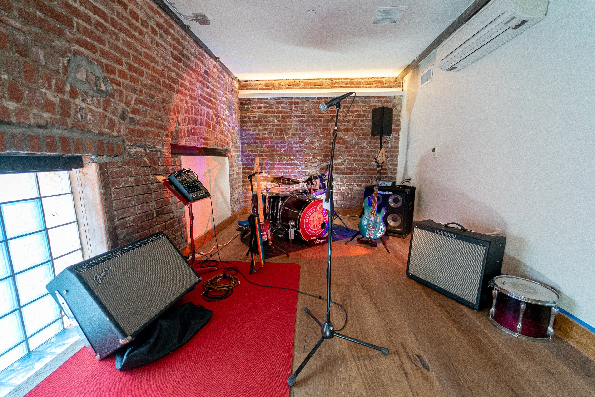Cozy rehearsal studio with exposed brick, ideal for intimate live music events.
