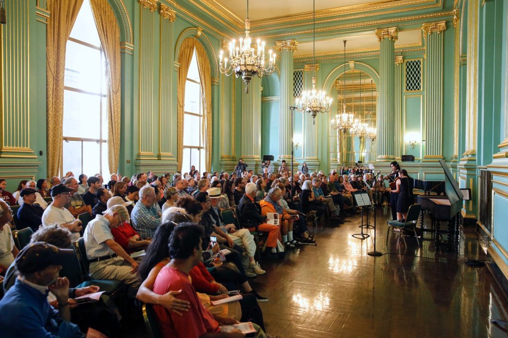 Engaged audience at elegant Center for New Music performance event with ornate decor.