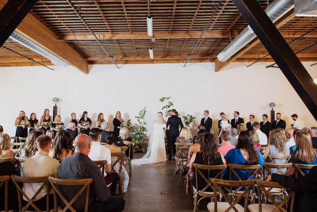 Elegant wedding ceremony setup in BLOC VENUE with natural light and greenery.