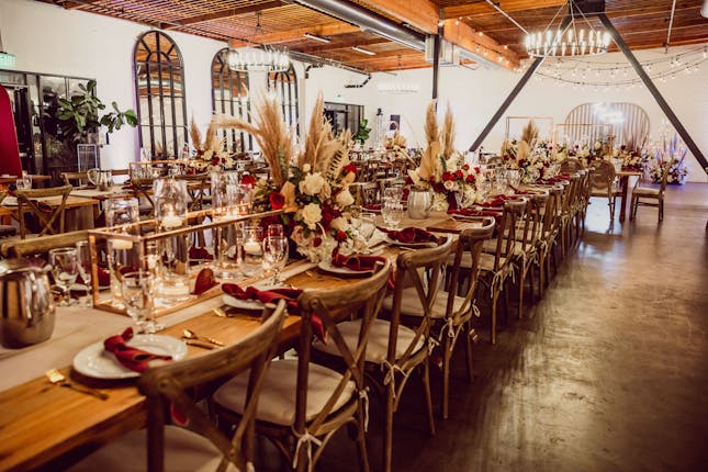 Elegant event space with wooden tables, ideal for weddings and corporate gatherings.